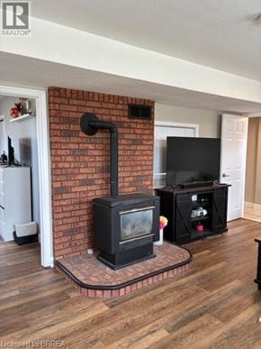 Paris apartment for rent - A wood stove is in a living room with a television.