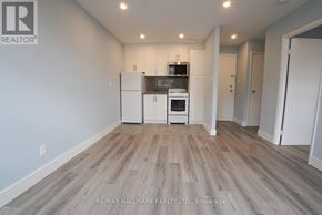 Toronto (East End-Danforth) multi-family for rent - A spacious room with a kitchenette and wooden flooring.