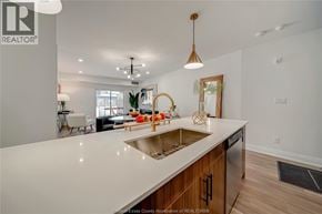 Tecumseh apartment for rent - A modern kitchen with a large island and wooden cabinets.
