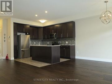 London North (North E) townhouse for rent - A kitchen with dark wood cabinets and a marble backsplash.