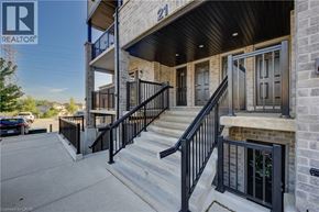 Kitchener townhouse for rent - A building with a black railing and steps leading to a door.