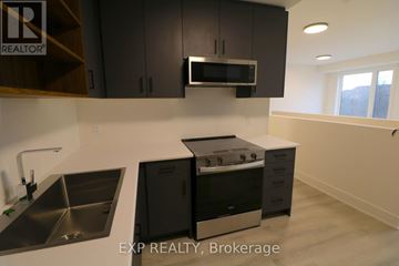 St. Catharines (Oakdale) townhouse for rent - A modern kitchen with black cabinets and stainless steel appliances.