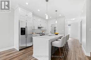 Quinte West (Murray Ward) townhouse for rent - A modern kitchen with white cabinets and a wooden floor.