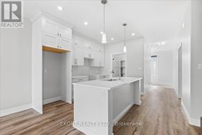 Quinte West (Murray Ward) townhouse for rent - A kitchen with white cabinets and a wooden floor.