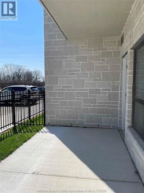 Windsor condo for rent - A grey stone wall with a black iron gate in front.