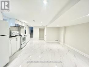 Toronto (Crescent Town) apartment for rent - A spacious kitchen with white appliances and marble flooring.