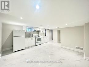 Toronto (Crescent Town) apartment for rent - A spacious kitchen with white appliances and cabinets.