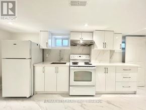 Toronto (Crescent Town) apartment for rent - A white kitchen with a refrigerator, stove, and cabinets.