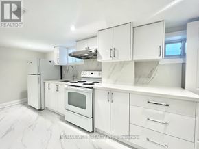 Toronto (Crescent Town) apartment for rent - A white kitchen with a stove, oven, and cabinets.