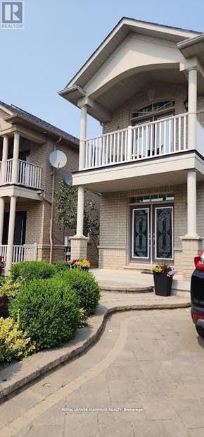 Vaughan apartment for rent - A house with a balcony and a car parked in front.