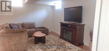 Vaughan apartment for rent - A living room with a large couch and a television.