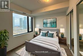 Vaughan (Concord) condo for rent - A bedroom with a large bed and a city view through the window.