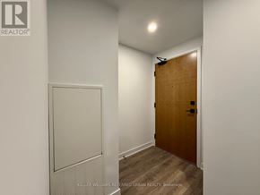 Vaughan (Concord) condo for rent - A hallway with a wooden door and a white wall.