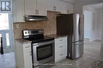 Barrie (Allandale Heights) apartment for rent - A kitchen with white cabinets and a black refrigerator.