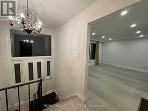 Barrie (Allandale Heights) apartment for rent - A chandelier hangs over a staircase with white walls and wood flooring.