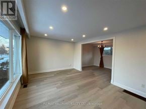 Barrie (Allandale Heights) apartment for rent - A spacious room with wood flooring and a chandelier.