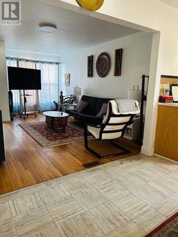 Cornwall triplex for rent - A living room with a black and white couch and a flat screen TV.