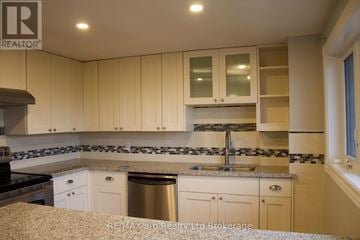Woodstock (Woodstock - North) apartment for rent - A kitchen with beige cabinets and a black stove top oven.