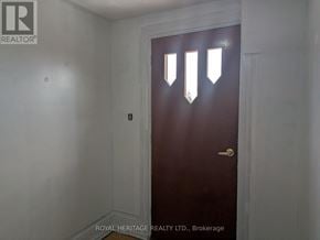 Oshawa (Central) multi-family for rent - A dark brown door with a gold handle in a white room.
