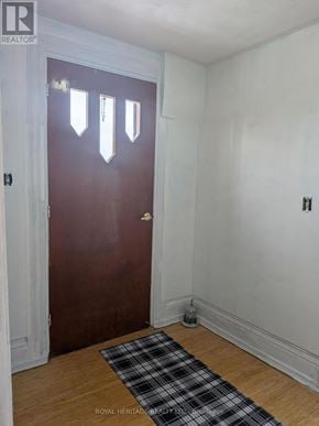 Oshawa (Central) multi-family for rent - A brown door with a white frame is in a room with white walls.