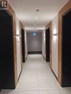 Toronto (Bay Street Corridor) condo for rent - A long hallway with doors on both sides and a blue sign in the middle.