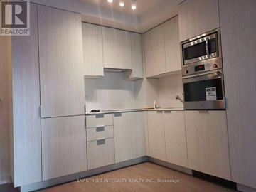 Toronto (Bay Street Corridor) condo for rent - A kitchen with white cabinets and a microwave above the stove.