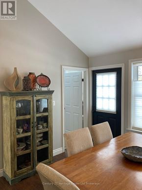 Tillsonburg apartment for rent - A wooden cabinet with glass doors is filled with various vases and decorative items.