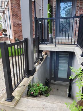 Toronto (Corso Italia-Davenport) fourplex for rent - A black metal railing on a concrete staircase.