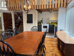 Blue Mountains apartment for rent - A wooden dining table with chairs and a television mounted on the wall.