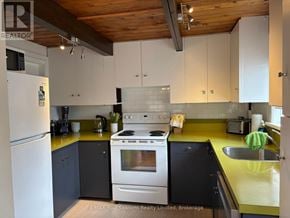 Blue Mountains apartment for rent - A kitchen with a white refrigerator, a white stove, and a yellow counter.