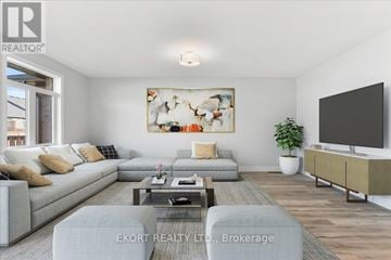 Quinte West (Murray Ward) townhouse for rent - A living room with a grey sofa, a coffee table, a television, and a painting on the wall.