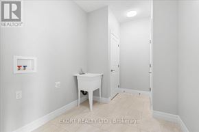 Quinte West (Murray Ward) townhouse for rent - A white bathroom with a sink, toilet, and a white chair.