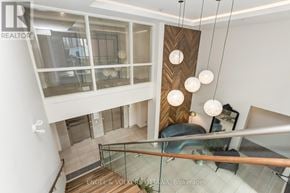 Ottawa multi-family for rent - A modern interior space with a staircase and hanging lights.
