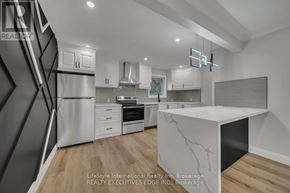 Guelph (St. George's) apartment for rent - A modern kitchen with a white marble island and wooden flooring.