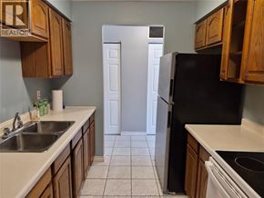Windsor apartment for rent - A kitchen with a sink, refrigerator, and cabinets.