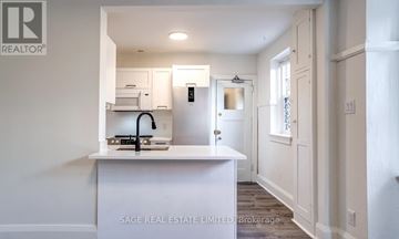 Toronto (Yonge-St. Clair) townhouse for rent - A white kitchen with a sink and a refrigerator.
