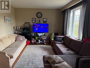 Toronto (Newtonbrook West) apartment for rent - A living room with a large couch, a television, and a rug.