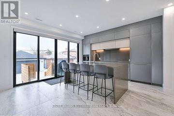Toronto (Caledonia-Fairbank) apartment for rent - A modern kitchen with a bar area and a view of the outdoors.
