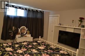 Mississauga (Lakeview) apartment for rent - A bedroom with a floral bedspread and a television on a stand.