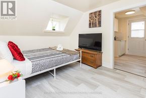 Ottawa apartment for rent - A bedroom with a bed, a dresser, and a television.