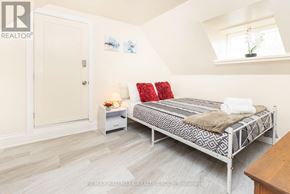 Ottawa apartment for rent - A bedroom with a bed, nightstand, and a window.