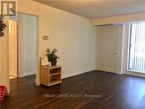 Toronto (Willowdale East) condo for rent - A room with wooden floors and white walls, furnished with a wooden shelf and a plant.