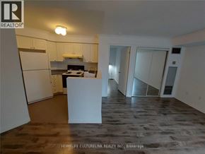 Toronto (Newtonbrook East) condo for rent - A kitchen area with a refrigerator, a counter, and a dining table.