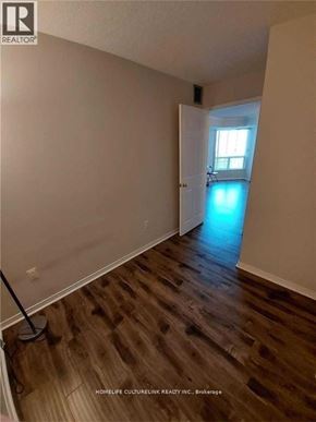 Toronto (Newtonbrook East) condo for rent - A room with wooden floors and a brokerage sign on the wall.