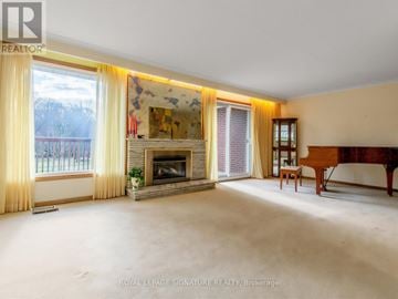 Toronto (Woburn) apartment for rent - A spacious living room with a fireplace and a painting on the wall.