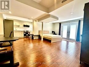 Vaughan (Maple) apartment for rent - A spacious room with wooden flooring and a bed in the corner.