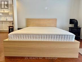 Vaughan (Maple) apartment for rent - A bed with a wooden frame and mattress in a room.