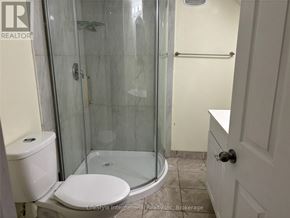 Guelph (Clairfields/Hanlon Business Park) apartment for rent - A white toilet sits next to a glass shower stall in a bathroom.