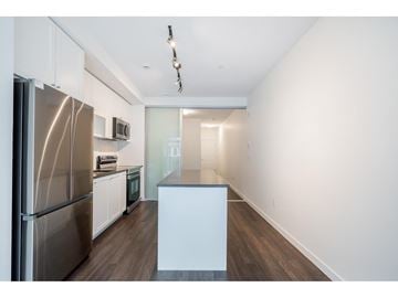 Surrey apartment for rent - A kitchen with a stainless steel refrigerator and white cabinets.