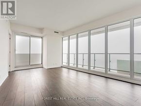 Toronto (Mount Pleasant West) condo for rent - A spacious room with wooden floors and large windows.